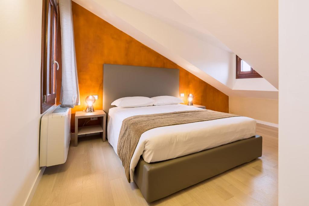 ein Schlafzimmer mit einem großen Bett im Dachgeschoss in der Unterkunft Charming Palace Corte del Teatro in Venedig