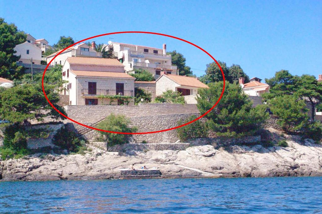 a house on a hill next to the water at Apartments and rooms by the sea Puntinak, Brac - 12255 in Selca