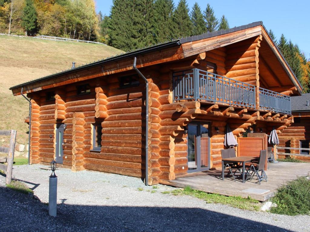 a log cabin with a balcony and a table at Jenig 5A in Jenig