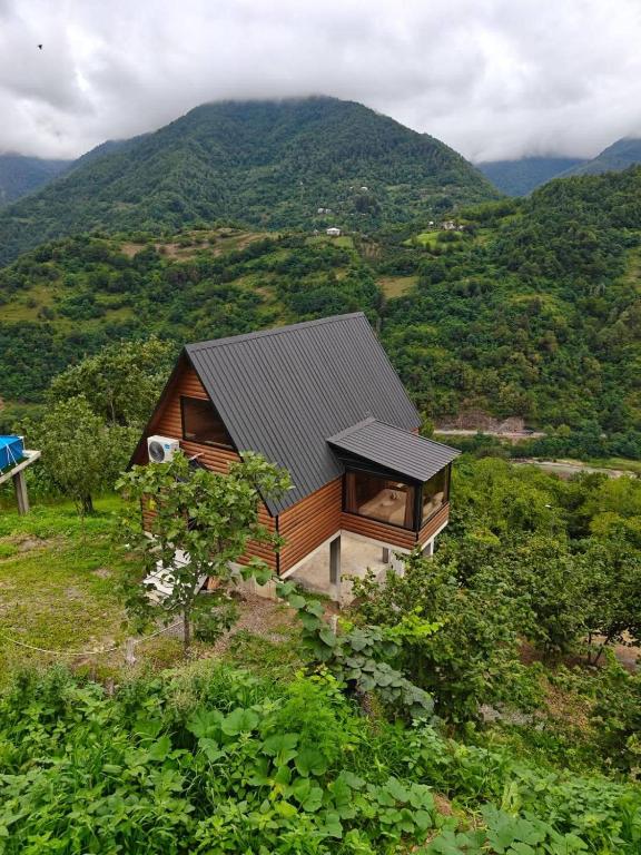a house on a hill with mountains in the background at Keda Horizon cottage in K'eda