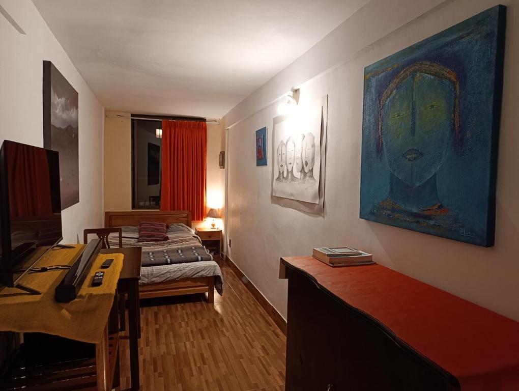 a room with a bedroom with a bed and a desk at Artistic Mini Loft & Sun Terrace in La Paz