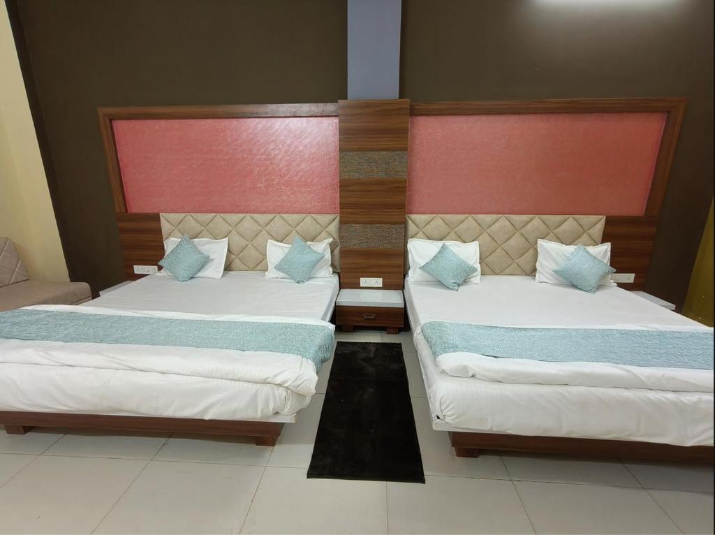 two beds in a hotel room with at Athithi Bhawan in Godarpura