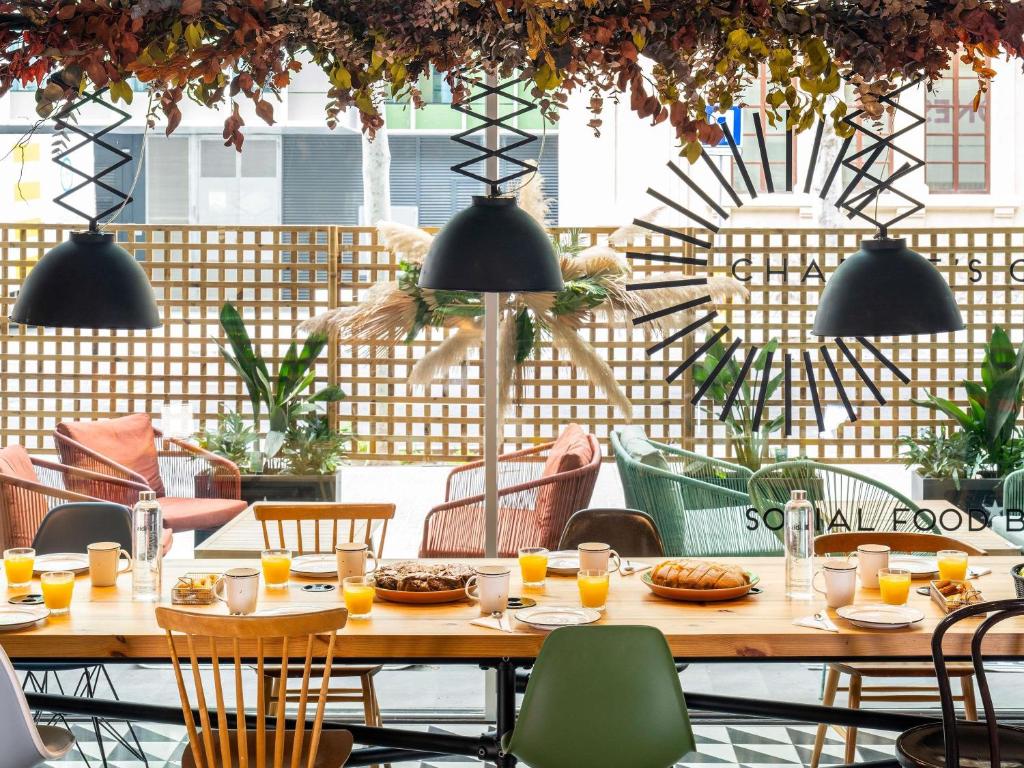 a table with plates of food on it in a restaurant at Ibis Barcelona Plaza Glòries 22@ in Barcelona