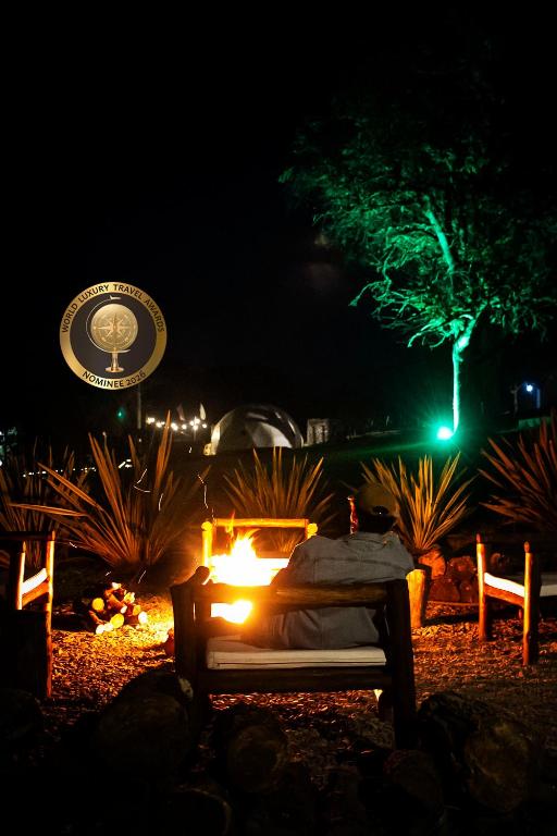 a bed with a fire in front of a sign at night at Willkay Glamping in Tafí Viejo