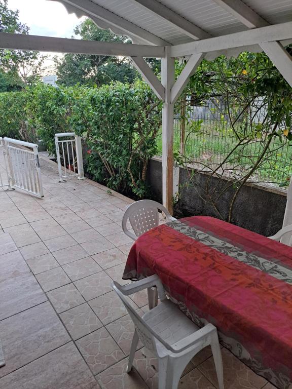 a porch with a table and chairs on a patio at Studio spacieux au calme in Capesterre