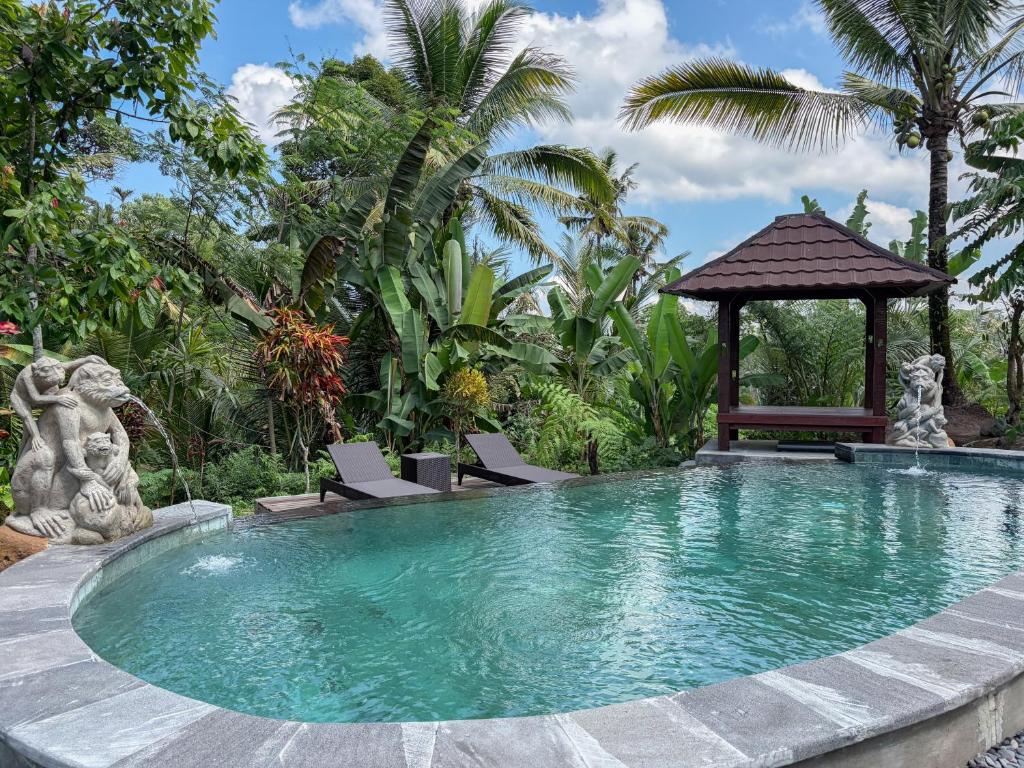 a swimming pool in a resort with a gazebo at Pondok Risky in Tegalalang