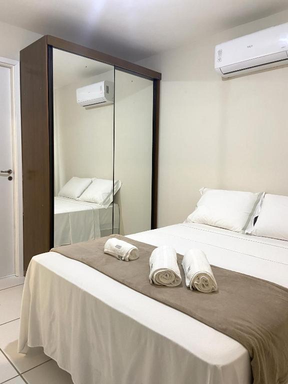 a bedroom with a bed with towels on it at Apartamento Flores do Bosque in Garanhuns