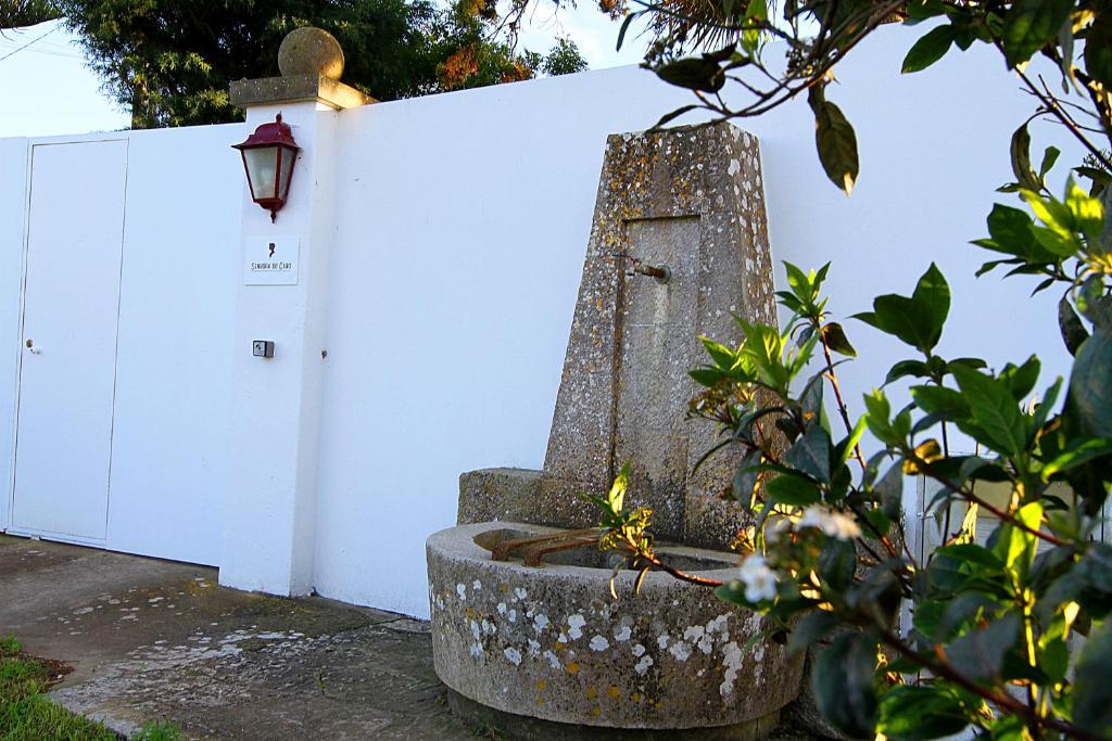 a stone monument in front of a white fence at Senhora do Cabo Meco Homy Holidays in Sesimbra