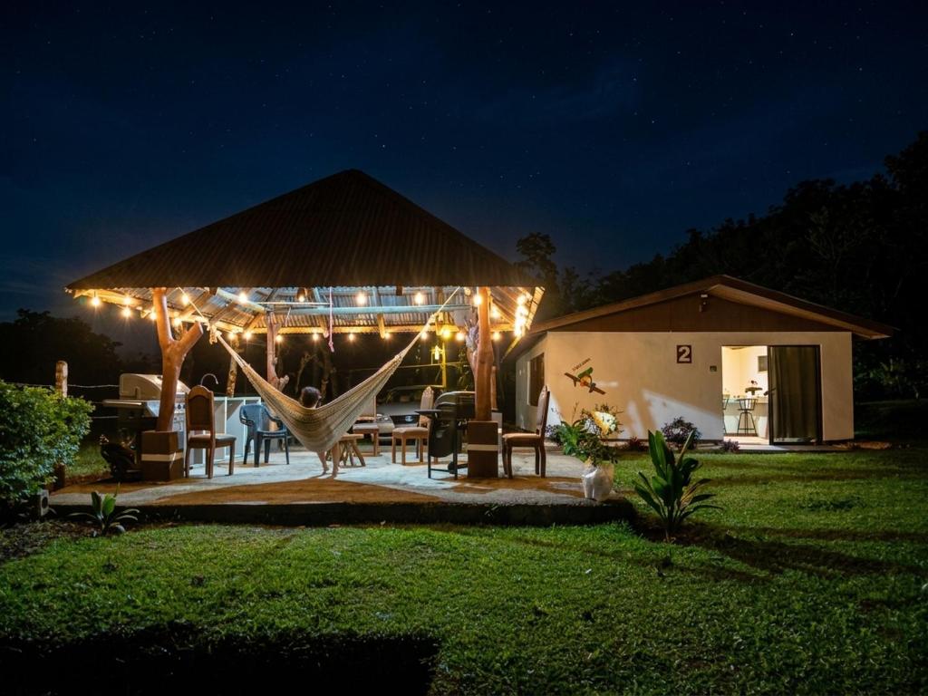 a patio with a hammock and a house at night at Hills Villa Rio Celeste in Rio Celeste