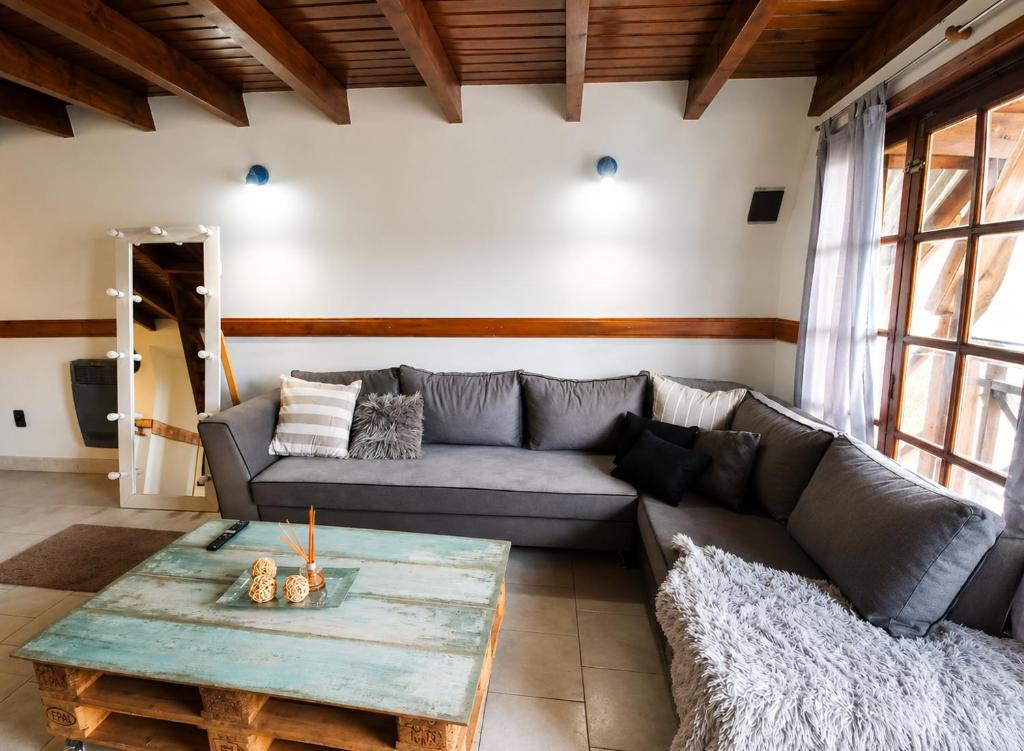 a living room with a couch and a table at Ushuaia Magnifica,cabaña con balcon,luminosa y calida in Ushuaia