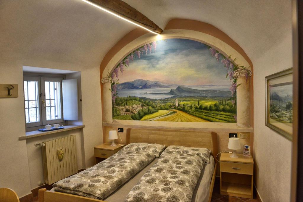 a bedroom with a painting on the wall and a bed at B&B Antiche Mura in Puegnano del Garda