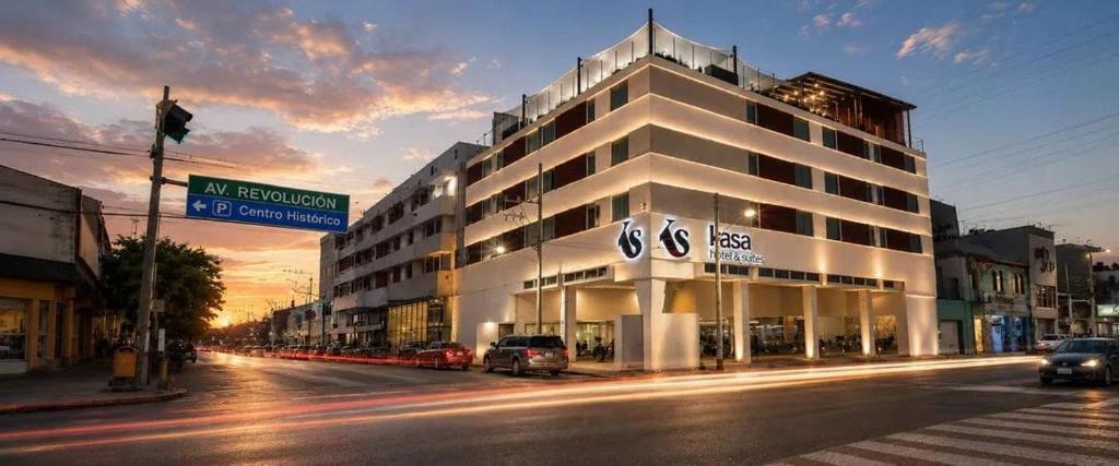 a large white building on a city street at night at Kasa Hotel & Suites in Irapuato
