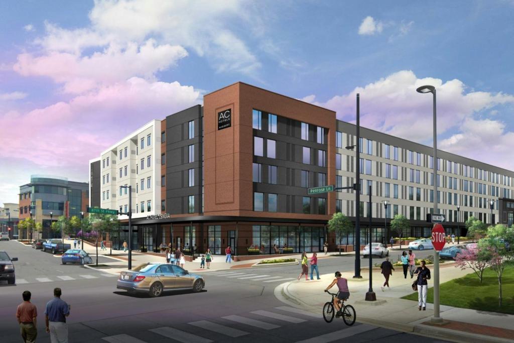 a rendering of a building with people crossing a street at AC Hotel Lenexa City Center in Lenexa