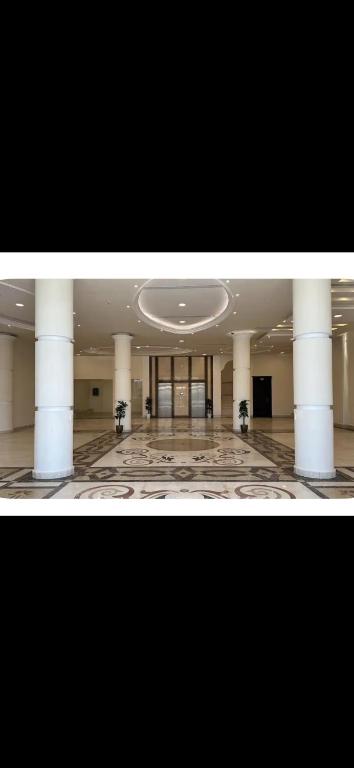 a large room with columns and a large hall with a building at Bohovibes in Buraydah