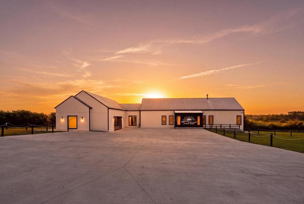 a large white building with a sunset in the background at Sunset Acres Ideal for all Occasions in Clermont