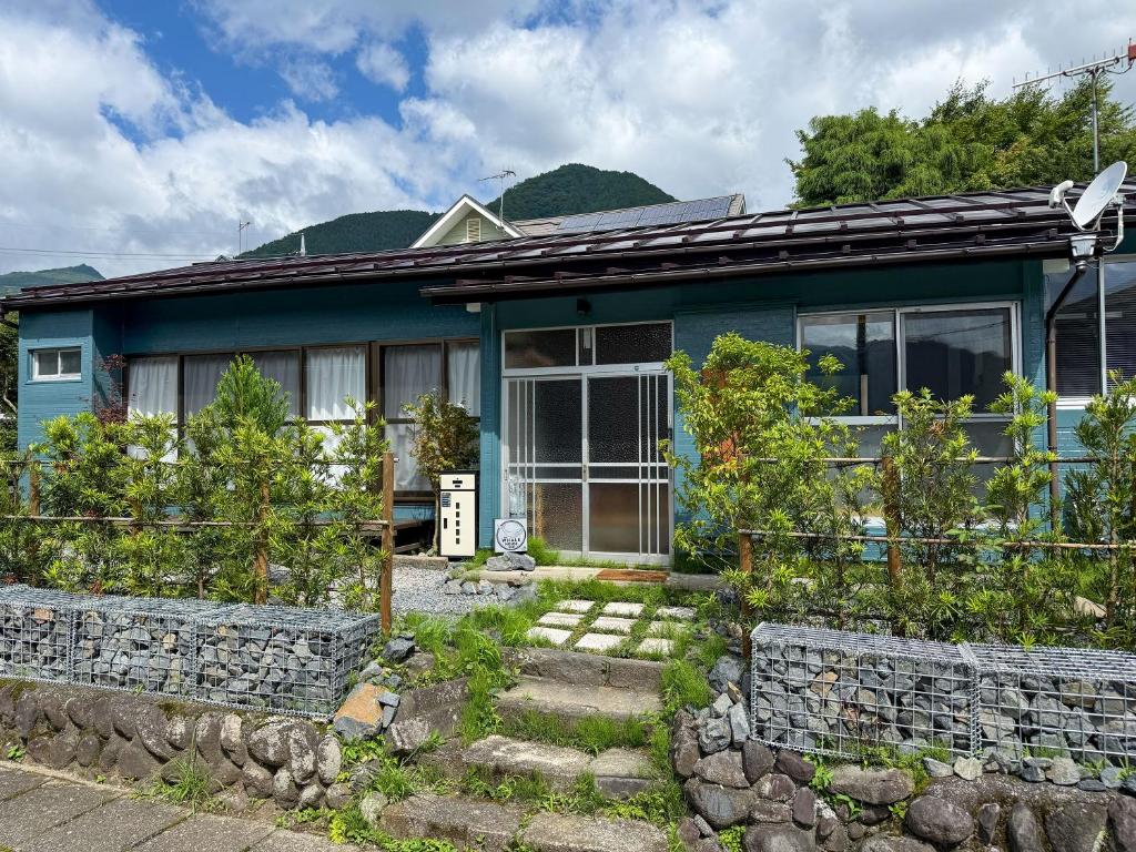 a blue house with a stone wall at The Whale House 日光 by Silver Daisy in Nikko