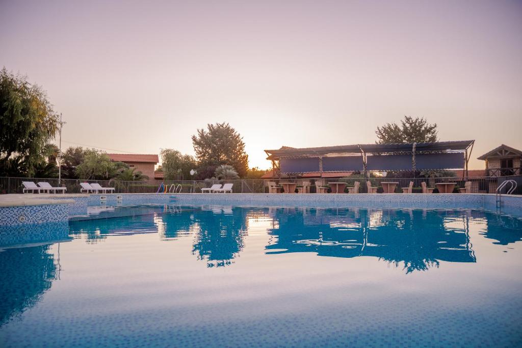 a large pool of water with a building in the background at Cabañas Costa Alta in Mina Clavero