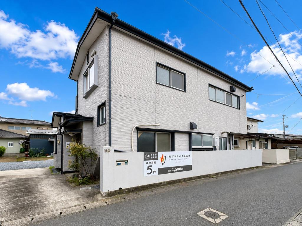 a building with a sign in front of it at 灯ゲストハウス石巻 in Ishinomaki