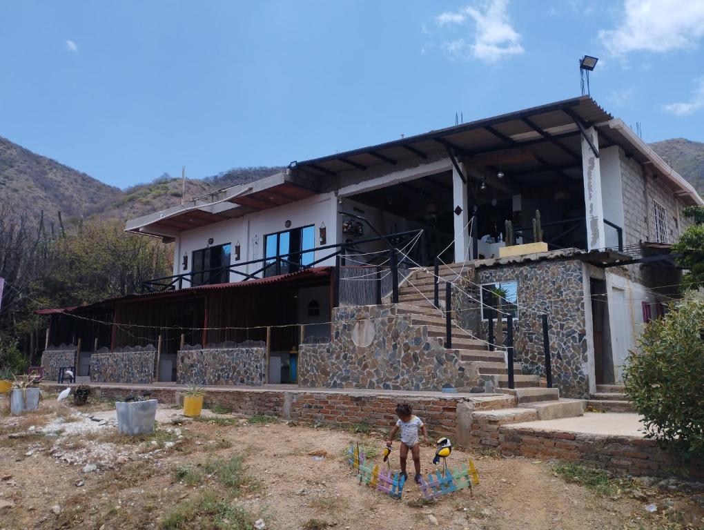 a young child standing in front of a house at brisas costeña in Santa Marta
