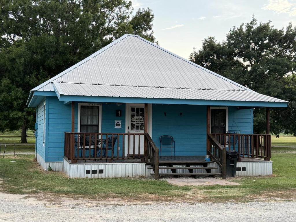 a blue house with a porch and a deck at Turn On Inn in Lake Village