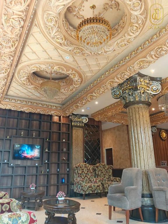 a living room with a ceiling with a chandelier at Da Rucci Hotel syariah in Medan