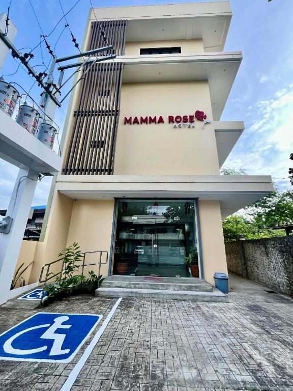 a manama rock building with a sign on it at Mamma Rose Hotel in Legazpi