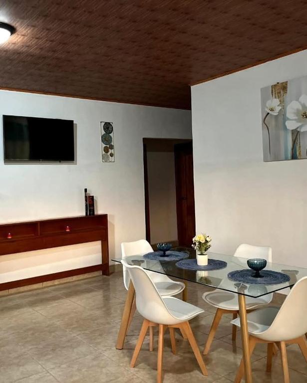 a dining room with a table and white chairs at La Casa de MiNi in La Ceiba