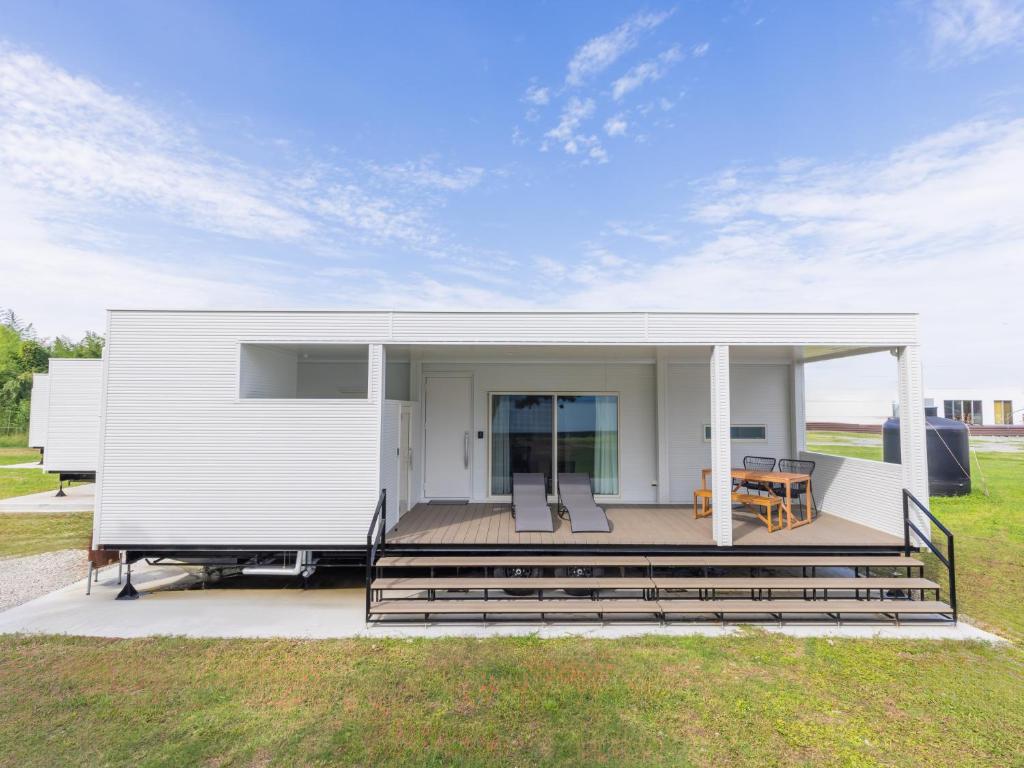 a white house with a deck and a table at Long Vacation Resort in Fukuoka