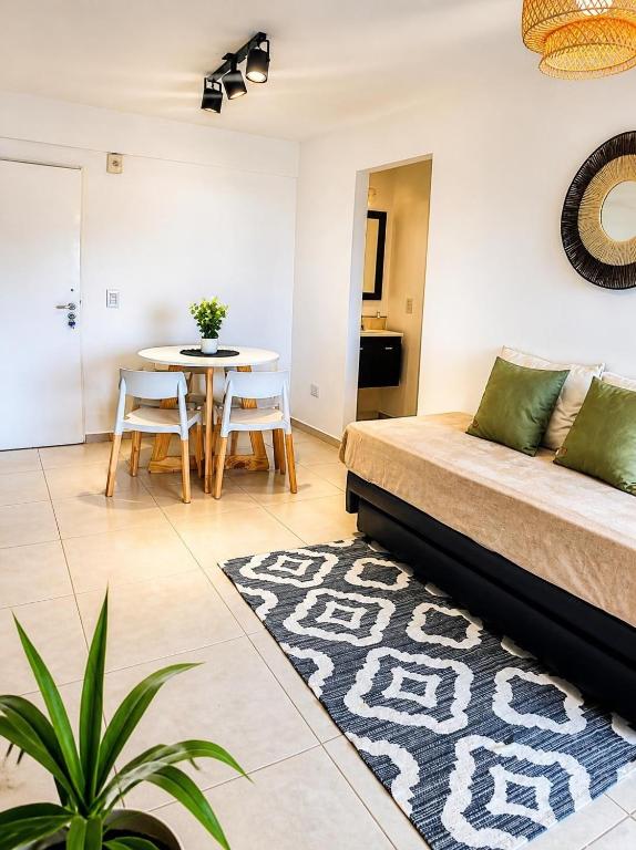 a living room with a bed and a table at LA RIVIERA María II - CON COCHERA in Villa María