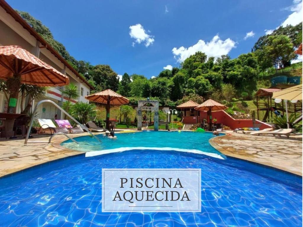 a swimming pool with a sign in front of a resort at Pousada Pompeia in Socorro