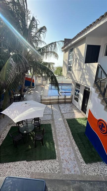 a patio with a table and umbrella next to a building at Hotel El Emigrante in Puerto Colombia