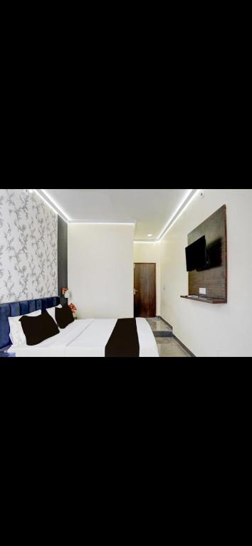a bedroom with a bed and a tv on the wall at Raj Embassy in Rudrapur
