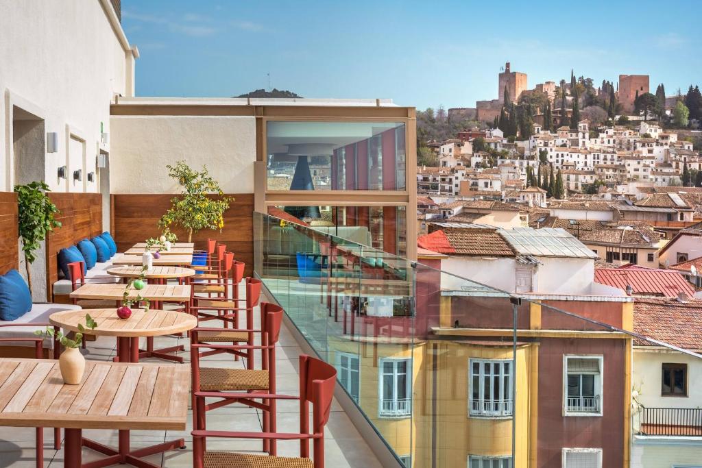 a balcony with tables and chairs on a building at Meliá Granada in Granada
