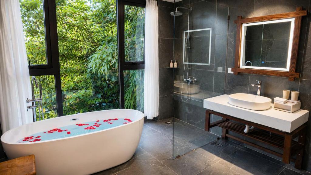 a bathroom with a tub and a sink and a mirror at Hai Yen Apartment in Sapa