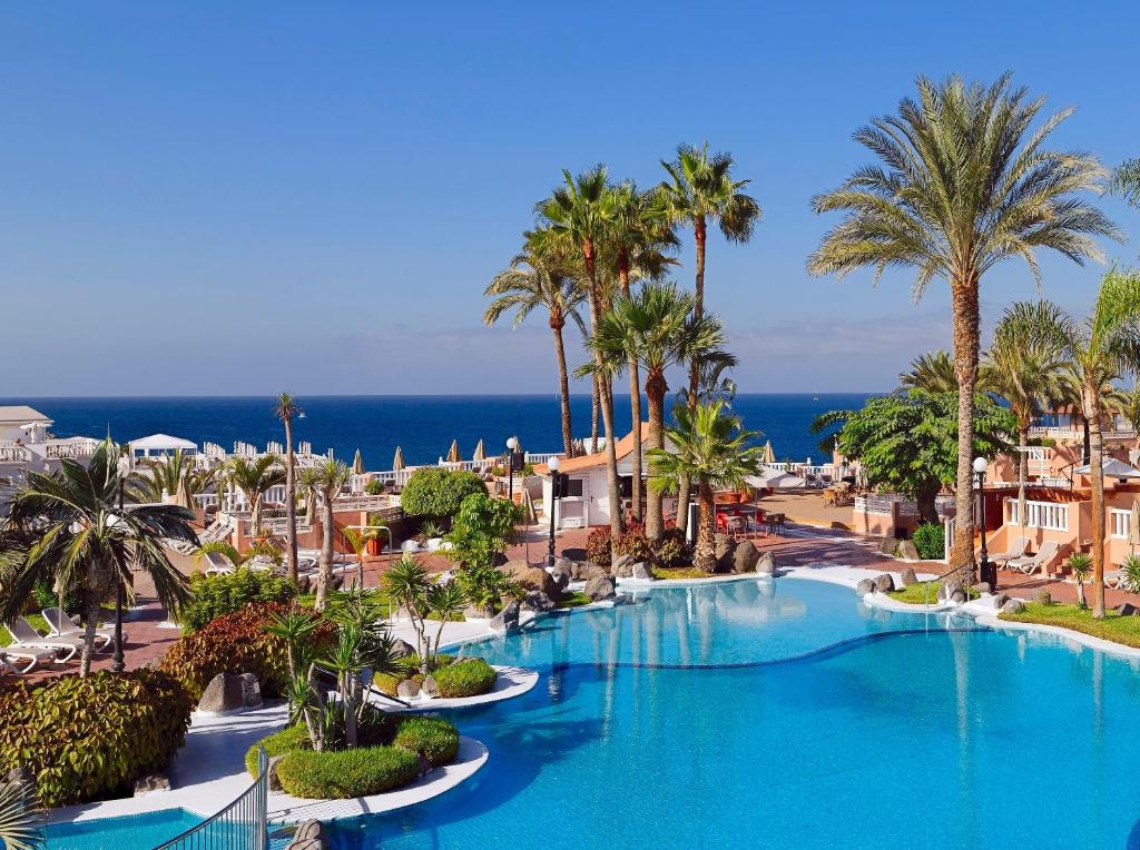 a resort with a large swimming pool with palm trees at SOL by Meliá Sun Beach Apartamentos in Adeje