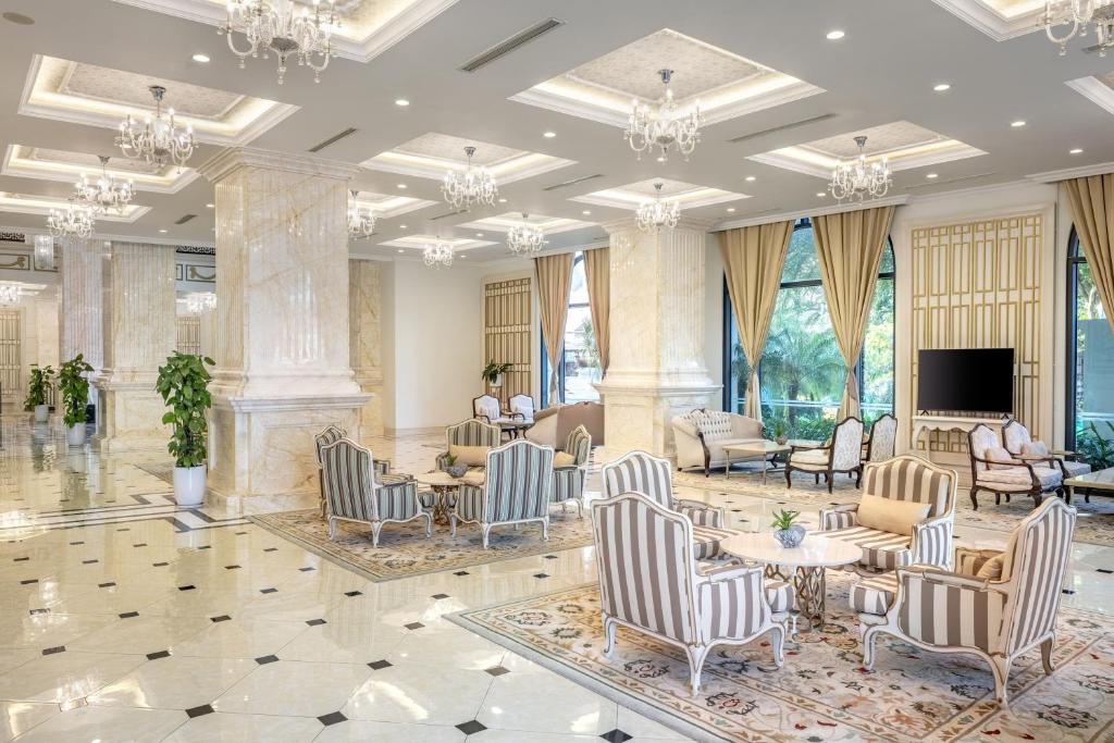 a lobby with chairs and tables and a television at Meliá Vinpearl Tay Ninh in Tây Ninh