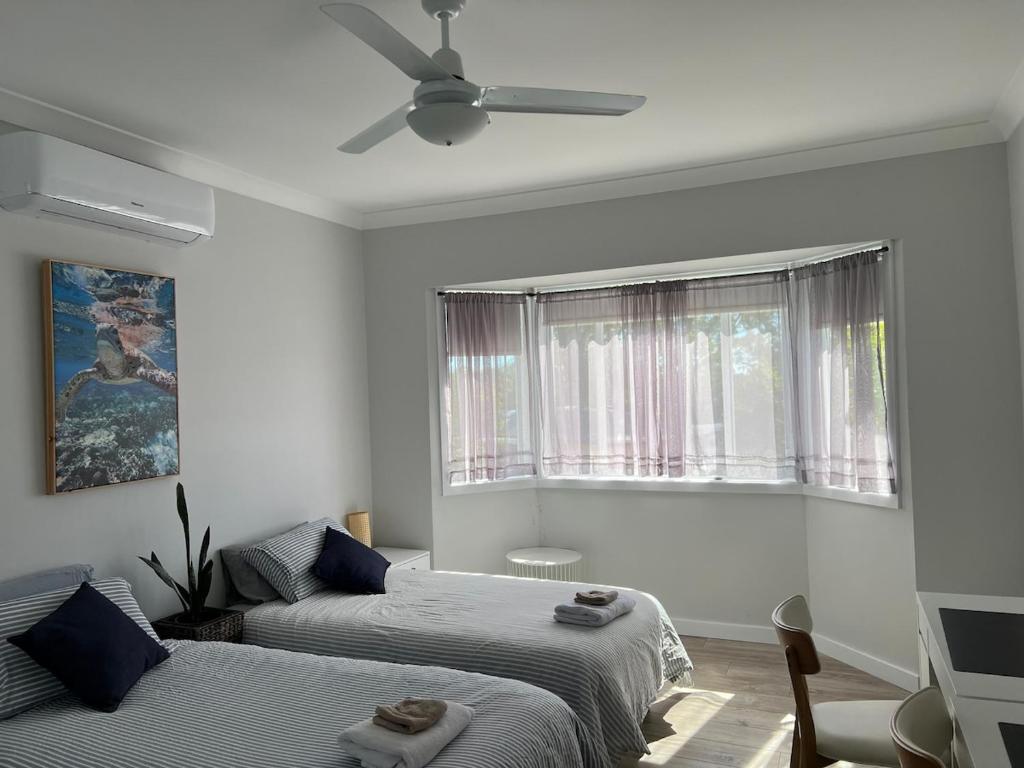 a bedroom with two beds and a ceiling fan at Large bedroom 2 King Single beds Centrally located in Jesmond