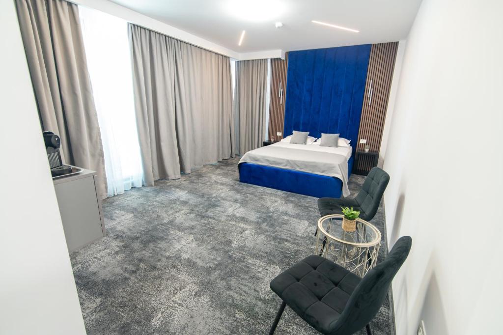 ein Hotelzimmer mit einem Bett und zwei Stühlen in der Unterkunft Simedo Boutique Hotel in Mamaia
