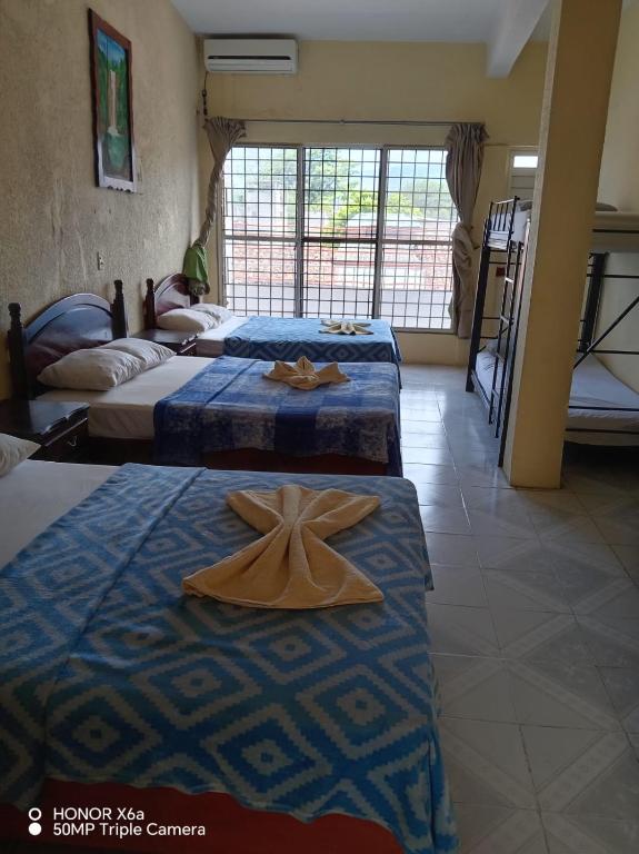 a room with three beds and a cross on them at Hotel Real in Chiapa de Corzo