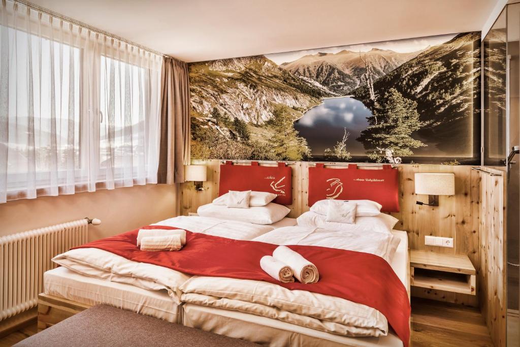 1 dormitorio con 1 cama grande y toallas. en schaus Lüftenegger - Apart-Zirbenpension, en Mauterndorf