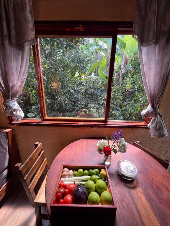 a wooden table with a tray of fruits and vegetables at Casa del Río, Vilcabamba in Loja