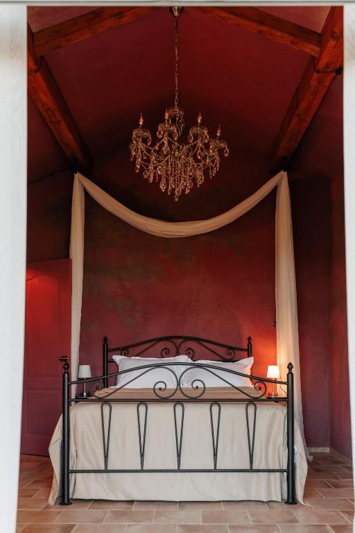a bedroom with a bed with a chandelier at KISLOV Vineyard Boutique Hotel in Hagimus