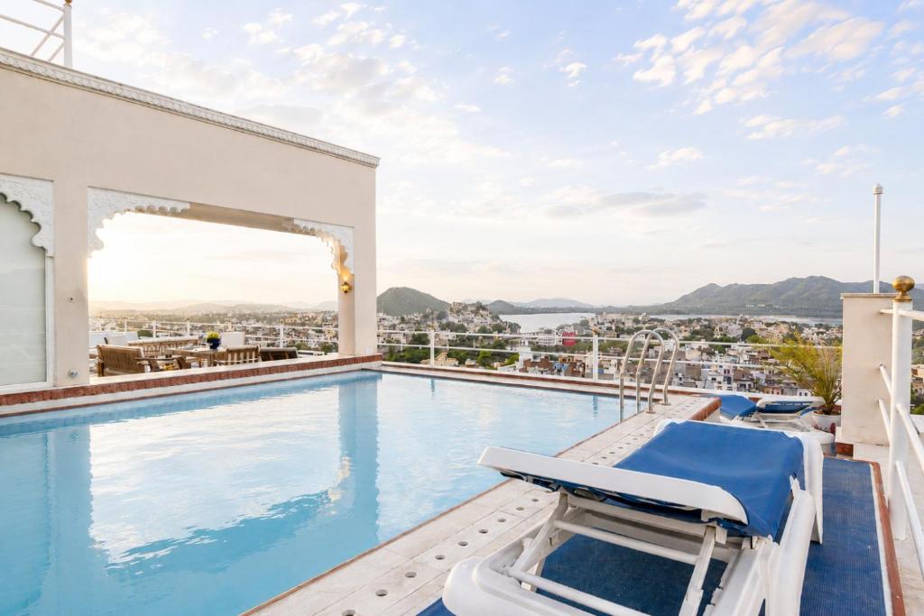 a pool on the roof of a house with a view at Raj Kuber - A Boutique Lake View Hotel in Udaipur