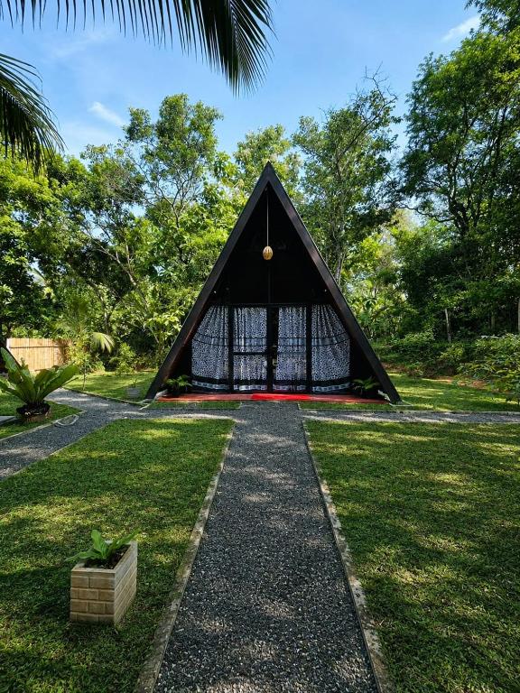a black triangular building in the middle of a park at Elephant Cabana Udawalawe in Udawalawe