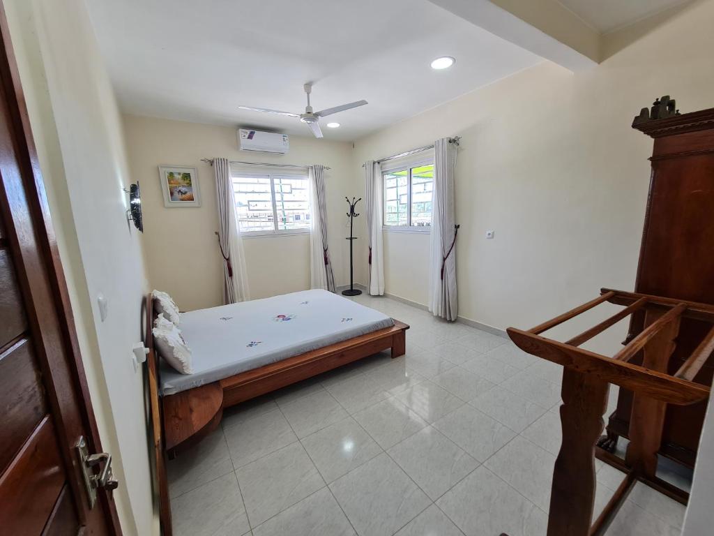 a bedroom with a bed in the corner of a room at BazarBe Appartment in Nosy Be