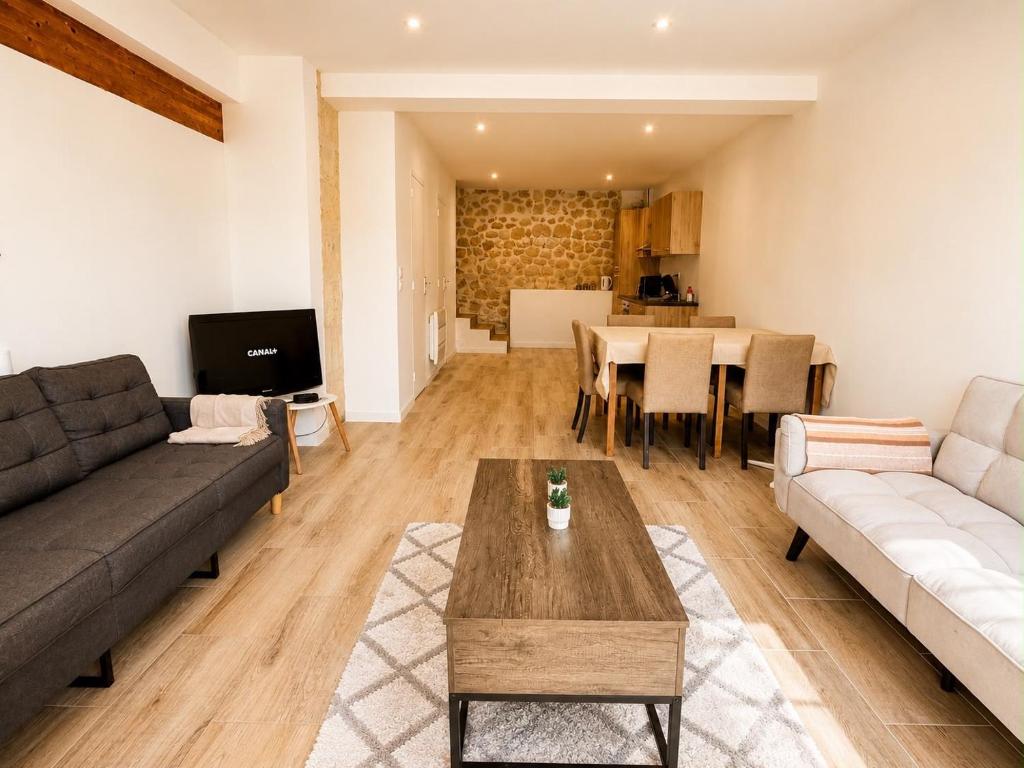 a living room with a couch and a table at Maison moderne 3 chambres avec terrasse Maison Familiale Région Bordeaux in Salleboeuf