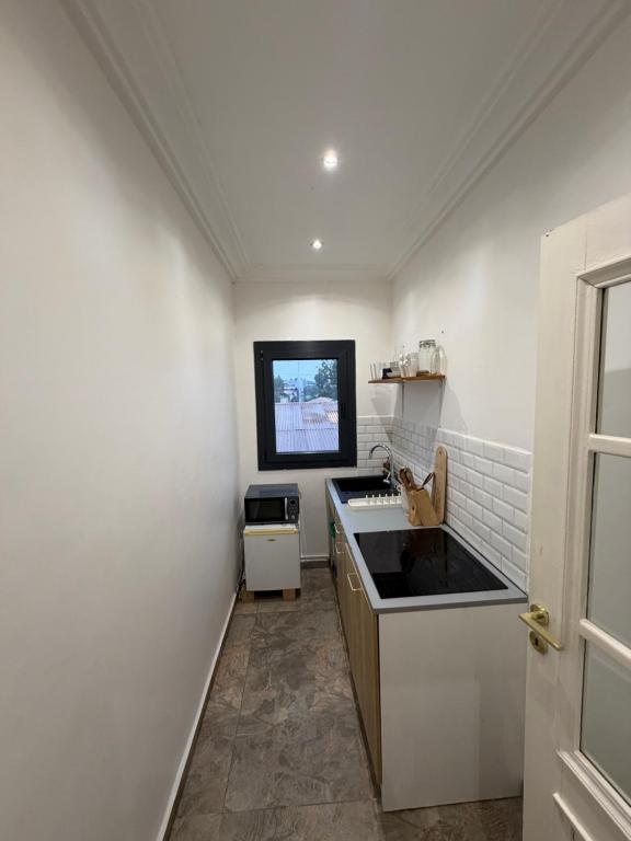 a white kitchen with a sink and a stove at KameronStudio in Yaoundé