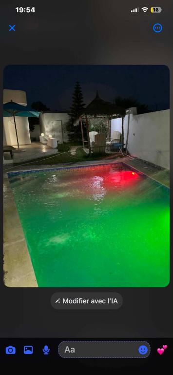 a television screen showing a pool with green and red illumination at Ridha in Djerba