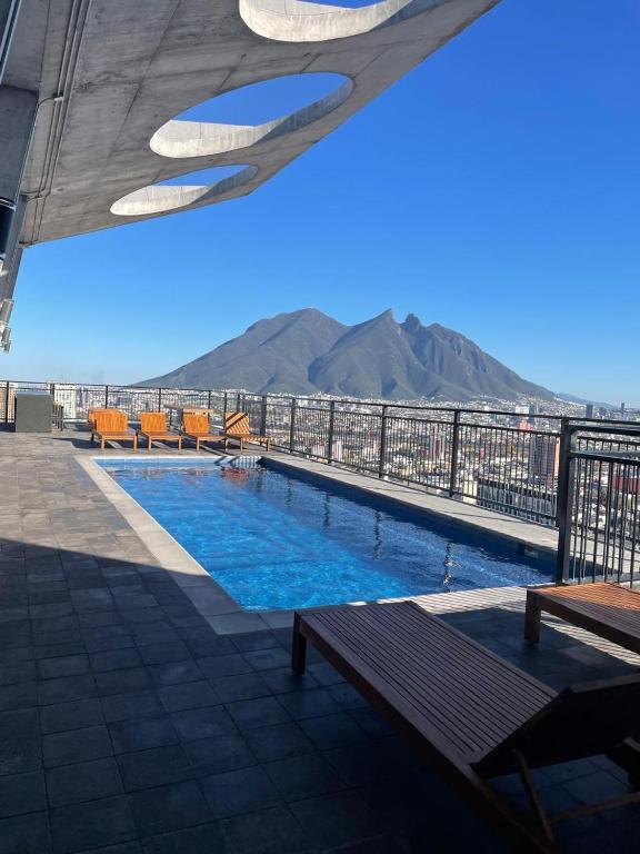 a pool on top of a building with mountains in the background at depa en el centro con estacionamiento in Monterrey