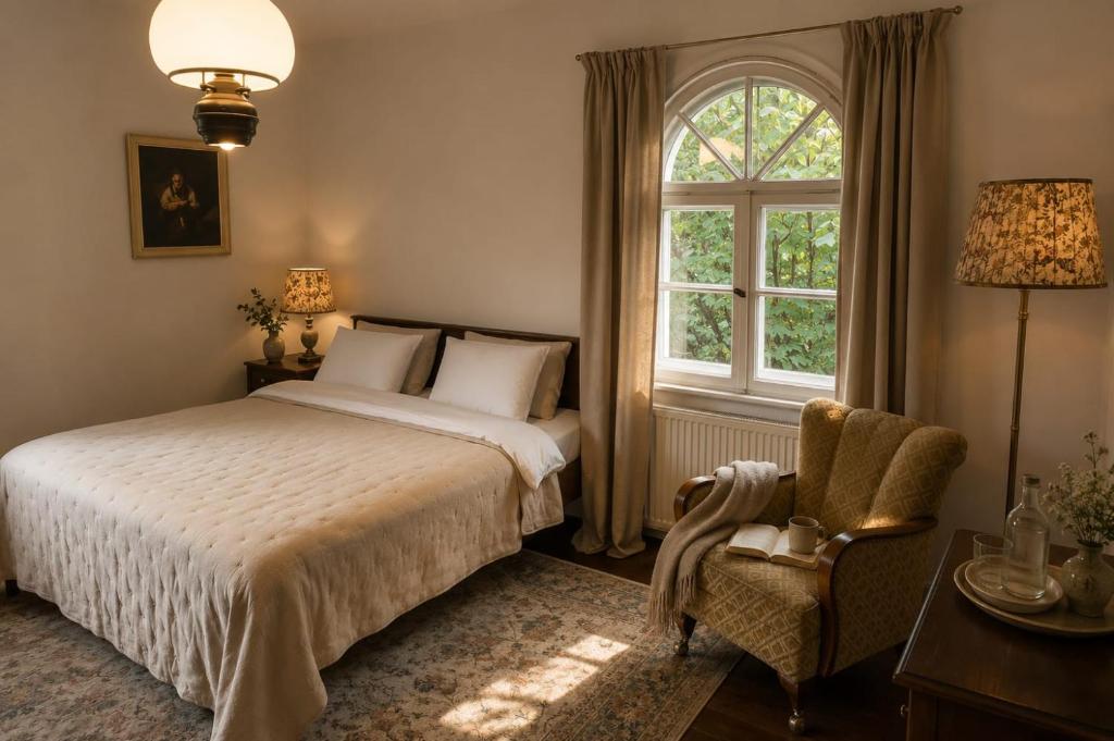 a bedroom with a bed and a window and a chair at HAUS 1926 Łagów Boutique Villa in Łagów